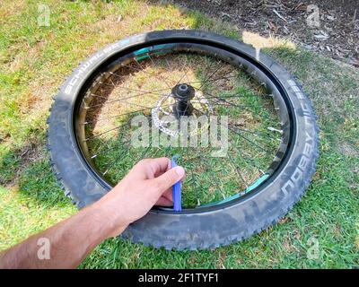 Primo piano della sostituzione degli pneumatici per biciclette con una nuova camera d'aria per la bicicletta Foto Stock