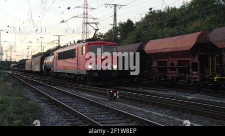 Una locomotiva per trasporto pesante di classe 155 con carri merci, gestita dalla DB Cargo GmbH, in serata a Colonia Gremberg, Germania, Europa. Foto Stock