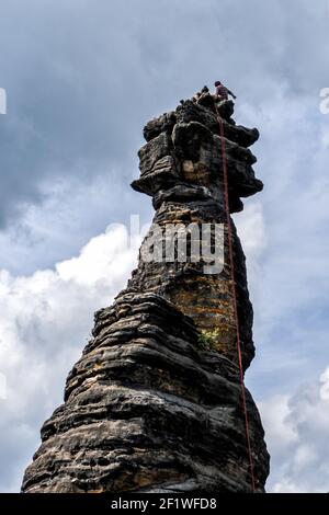 Arrampicatori su una colonna di roccia in Montagne di Elbsandstone nella Svizzera sassone Foto Stock