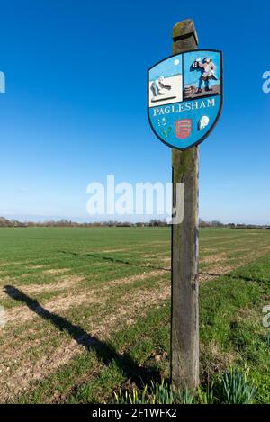 Cartello del villaggio di Paglesham, con dipinti in rilievo raffiguranti coloro che lavoravano sulla terra e sul mare, dove il cowslip (paigle nella vecchia Sassonia) diede il suo nome Foto Stock