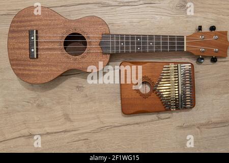 Kalimba 17 chiavi e ukulele su sfondo di legno nero. Strumento musicale africano. Pianoforte a pollice con copyspace. Foto Stock