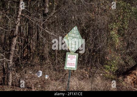 Burke County, GA USA - 12 27 20: Scarico locale traboccante da Natale rifiuti e segno di avviso rifiuti Foto Stock