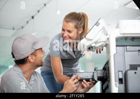 lavoratori felici che riparano una stampante Foto Stock