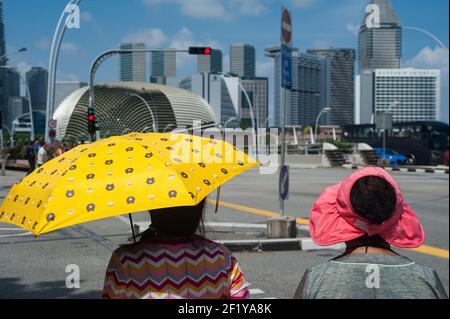 03.02.2018, Singapore, Repubblica di Singapore, Asia - i turisti asiatici aspettano al semaforo lungo Esplanade Drive a Marina Bay con skyline della città. Foto Stock