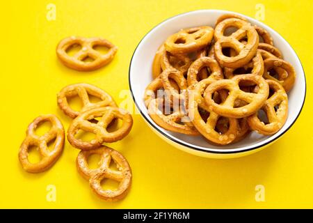 Pretzel in una piastra su uno sfondo isolato. Struttura pretzel. Ricci salati sul tavolo. Foto Stock