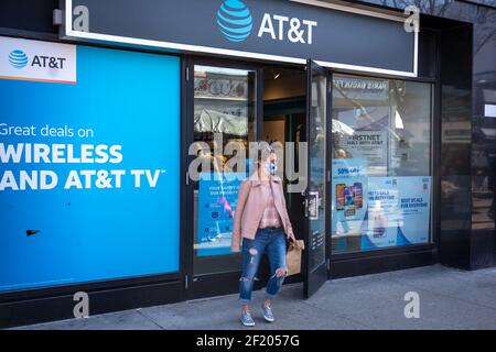 NEW YORK, NY - 9 MARZO: Una donna esce da un negozio AT&T Wireless a Queens il 9 marzo 2021 a New York City. La Securities and Exchange Commission (SEC) ha citato in giudizio AT&T e tre dirigenti AT&T, affermando che il gestore wireless ha trapelato dati non pubblici sulla diminuzione delle vendite telefoniche agli analisti al fine di convincere gli analisti a modificare le previsioni di fatturato. Questo schema ha aiutato AT&T a "battere" le previsioni di fatturato degli analisti nel primo trimestre del 2016, ha dichiarato la SEC. Credit: Ron Adar/Alamy Live News Foto Stock