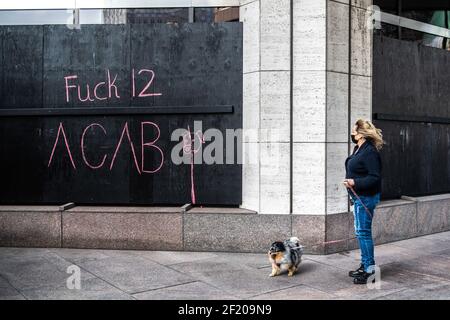 Una donna che cammina il suo cane si ferma a leggere l'arte del gesso sul muro di fronte alla strada dal tribunale della contea di Hennepin il 9 marzo 2021 a Minneapolis, Minnesota. La selezione della giuria è prevista per iniziare oggi nel processo dell'ex ufficiale di polizia di Minneapolis Derek Chauvin nella morte di George Floyd lo scorso maggio. Foto: Chris Tuite/ImageSPACE/MediaPunch Foto Stock