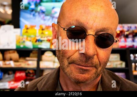Tilburg, Paesi Bassi. L'uomo calvo che indossa gli occhiali da sole  all'interno di un negozio di e-sigarette, informando il himslef circa la  nicotina socalled ha sostituito fumare Foto stock - Alamy
