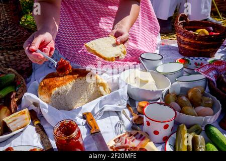 Pasto tradizionale, marmellata di strisci di donna sul pane, colazione in aperto al momento della raccolta. Foto Stock