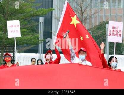 Hong Kong, Cina. 6 marzo 2021. I cittadini esibiscono la bandiera nazionale cinese a sostegno dell'attuazione del principio dei "patrioti che amministrano Hong Kong" al Tamar Park di Hong Kong, Cina meridionale, il 6 marzo 2021. Credit: Li Gang/Xinhua/Alamy Live News Foto Stock