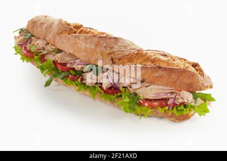 Appetitoso sandwich di baguette con pezzi di pollo e verdure mature posizionato su sfondo bianco Foto Stock