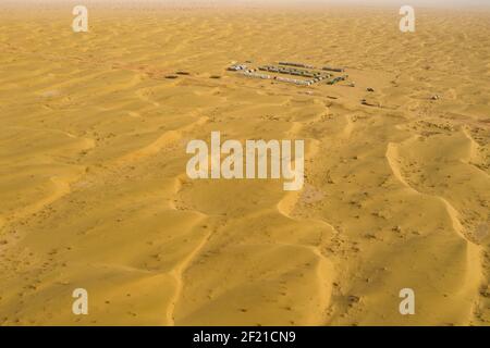 (210310) --URUMQI, 10 marzo 2021 (Xinhua) -- Foto aerea mostra il sito del campo della squadra geofisica di rilevamento nel deserto di Taklimakan, regione autonoma di Xinjiang Uygur, 25 febbraio 2021. Il deserto di Taklimakan, situato nel bacino di Tarim, nella regione autonoma di Xinjiang Uygur, nella Cina nord-occidentale, è una delle principali regioni petrolferiche della Cina e una delle più difficili da esplorare a causa del suo ambiente terreno duro e delle complicate condizioni sotterranee. Per esplorare le risorse petrolifere e del gas sono necessari più processi, tra cui la conduzione di indagini geofisiche, in modo da raccogliere dati sismici Foto Stock