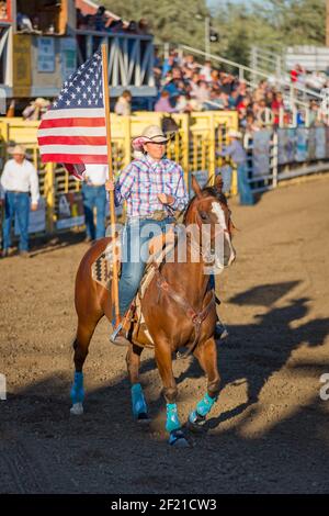 Guardia di colore con bandiera americana alle cerimonie di apertura di un rodeo, il Fort Dalles Rodeo, Oregon, USA Foto Stock