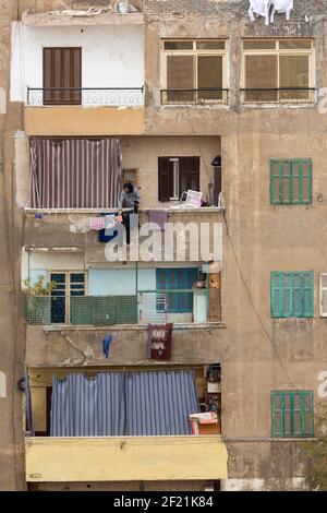 Un uomo egiziano locale che si sta lavando per asciugare su una terrazza di un piano superiore a Tolon, El-Sayeda Zainab, il Cairo, Egitto Foto Stock