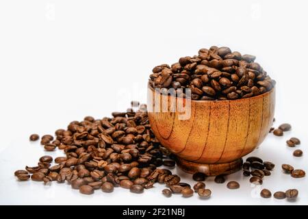 Chicchi di caffè. Chicchi di caffè arrosto in una ciotola di bambù. Isolato su sfondo bianco. Foto Stock