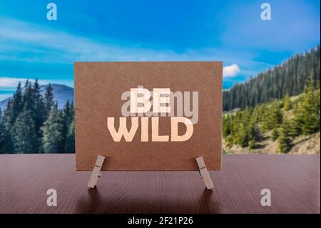 Sia il testo selvaggio sulla scheda sul tavolo con lo sfondo della valle della montagna. Foto Stock