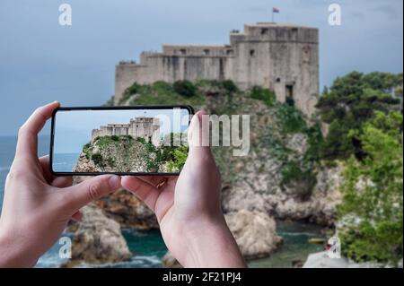 Turismo scattare foto delle fortezze Lovrijenac dalle mura della città di Dubrovnik a Dubrovnik, Croazia Foto Stock