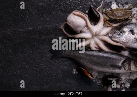 frutti di mare crudi assortiti su tavolo in marmo, immagine mock-up con spazio per il testo Foto Stock