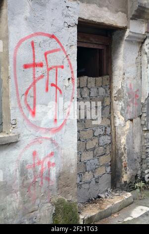 Dipinto di rosso carattere cinese 'cai', che significa demolizione. Le case sono mirate, residenti spostati fuori, porte bricked in su poi la demolizione inizia a un certo punto. Foto Stock