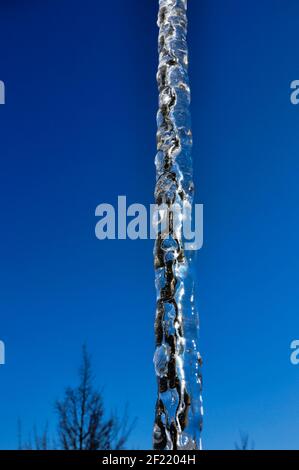 Catena metallica con ghiaccio davanti ad un bel blu cielo invernale Foto Stock