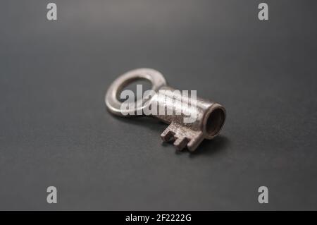 Piccola chiave di un vecchio lucchetto su sfondo nero Foto Stock