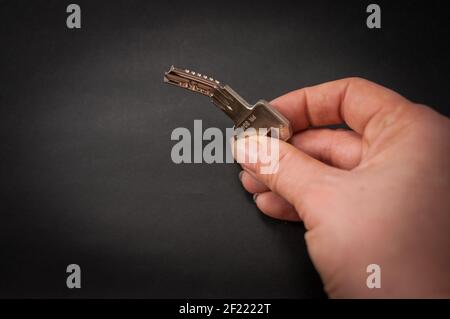 Uso improprio di chiavi concavità piegate, chiavi reversibili, chiavi a cilindro. Tenuto e mostrato da una mano destra, su uno sfondo nero Foto Stock