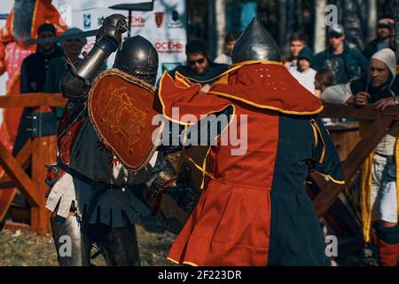 Due cavalieri combattono con le spade. Ricostruzione di una battaglia medievale nell'arena con il pubblico. Festival dei club storici. Bishkek, Kirghizistan - 13 ottobre 2019 Foto Stock