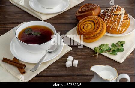 tè nero caldo in una tazza di porcellana bianca. concentrazione selettiva. tè aromatico con zucchero e menta. Foto Stock