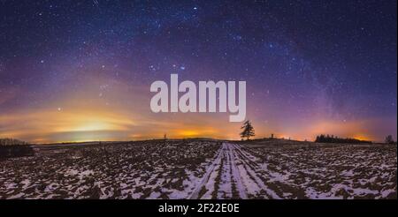 Galassia della Via Lattea, panorama del cielo notturno con stelle e neve in primo piano Foto Stock