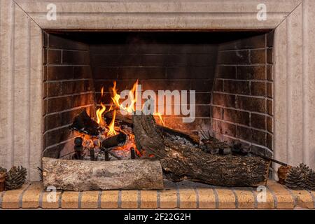 Fuoco incandescente in un grande camino di pietra. Foto Stock
