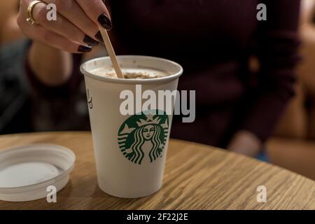 Barcellona, Spagna - 17 marzo 2019: Tazza di caffè con il logo Starbucks sul tavolo. Foto Stock