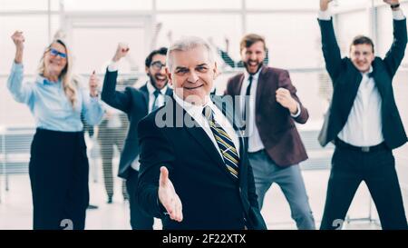 uomo d'affari anziano che tiene fuori la sua mano per una stretta di mano. Foto Stock