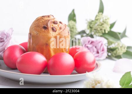 Mini panettone, uova rosa tinte naturali e fiori sul tavolo delle feste, brunch di Pasqua, festa Foto Stock