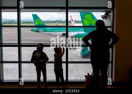 Madre e due bambini guardano gli aerei parcheggiati all'aeroporto di Dublino, Irlanda Foto Stock