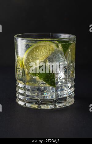 Fetta di lime con acqua frizzante in un bicchiere. Concetto di bevanda estiva. Foto Stock