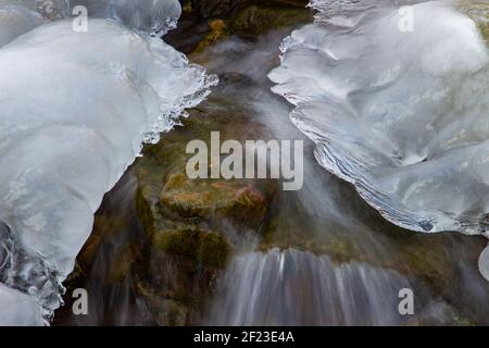 Acqua che scorre sotto ghiaccio fondente, concetto di riscaldamento globale Foto Stock