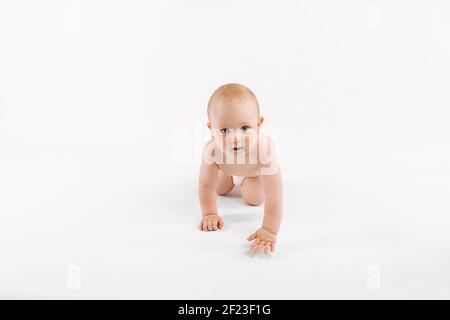 Felice bambino carino in pannolino strisciato su bianco isolato sfondo Foto Stock