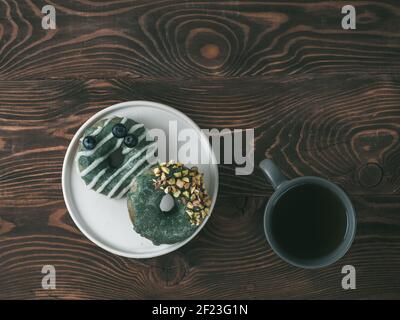 Ciambelle vegane condite con glassa di spirulina e tè Foto Stock