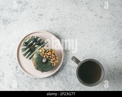 Ciambelle vegane condite con glassa di spirulina e tè Foto Stock