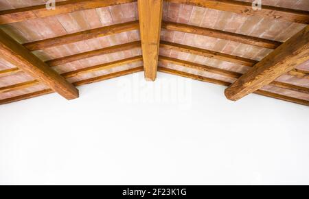 Soffitto tradizionale in legno di quercia toscano, motivi in mattoni rossi e pareti bianche come copyspace. Interni rurali italiani classici. Foto Stock