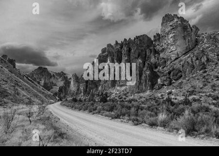 Nuvole scure rotolano sopra il remoto e surreale Leslie Gulch dell'Oregon sudorientale. Foto Stock