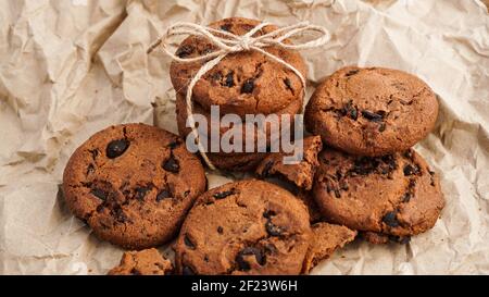 Vista su alcuni biscotti fatti a mano al cioccolato con scaglie di cioccolato sulla cottura carta Foto Stock