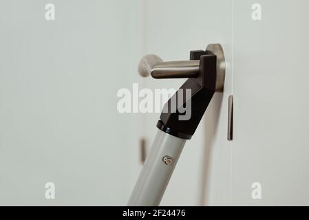 chiusura di una barra di sicurezza del blocco delle portiere in uso in una porta bianca Foto Stock