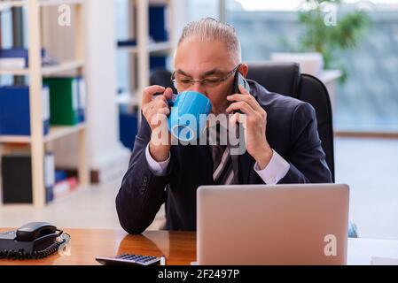 Vecchio dipendente di un uomo d'affari che lavora in ufficio Foto Stock