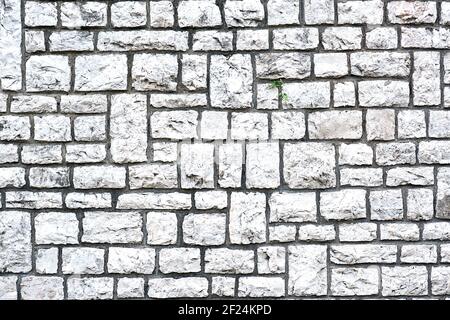 Sfondo da una parete fatta di pietre naturali a forma di blocco Foto Stock