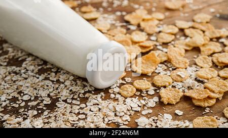 Bottiglia di latte fresco su fondo di legno con avena e cereali Foto Stock