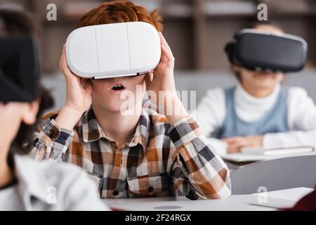 messa a fuoco selettiva di gioco sbalordito per scolaresche con visore vr in in aula Foto Stock