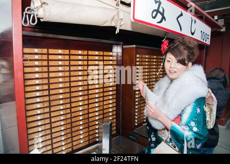 Bella donna giapponese in kimono controllo omikuji fortuna raccontare su venuta di Age Day (Seijin no hi), senso-ji Tempio, Asakusa, Tokyo, Giappone Foto Stock