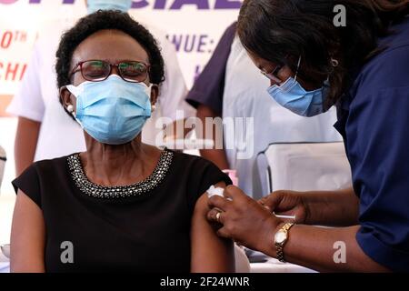 (210310) -- KAMPALA, 10 marzo 2021 (Xinhua) -- il Ministro della Salute dell'Uganda Jane Ruth Aceng (L) riceve un vaccino COVID-19 durante il lancio della campagna di vaccinazione all'Ospedale specializzato Donne e neonatali di Mulago a Kampala, Uganda, 10 marzo 2021. L'Uganda ha lanciato mercoledì la prima fase della campagna di vaccinazione COVID-19 rivolta ai gruppi ad alto rischio del paese dell'Africa orientale. (Foto di Hajarah Nalwadda/Xinhua) Foto Stock