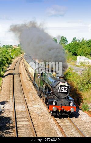 Un'onda dal taxi del GWR n. 6024 King Edward 1, come velocità oltre il sito della stazione precedente Wootton Bassett Junction. Foto Stock